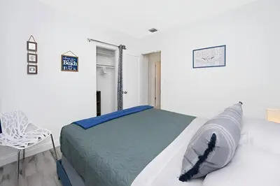 a white room with a bed and a chair at The Palm House in Hollywood