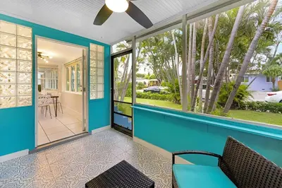 a home with a blue front porch with a couch at The Palm House in Hollywood