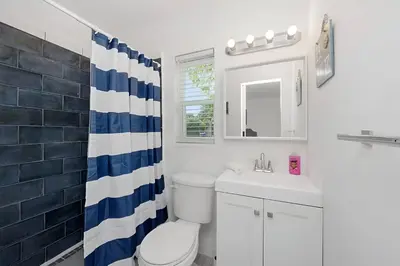 a bathroom with a toilet and a sink and a mirror at Luna Beach House in Hollywood