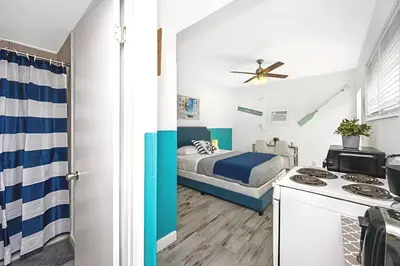 a small bedroom with a bed and a kitchen at Blue Coral Studio in Hollywood