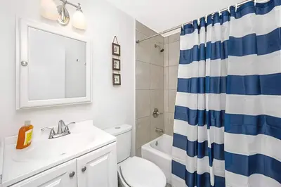 a bathroom with a toilet sink and a shower curtain at Blue Coral Studio in Hollywood