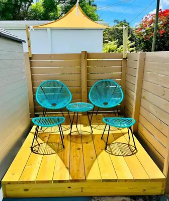 three chairs and a table on a wooden deck at Blue Coral Studio in Hollywood