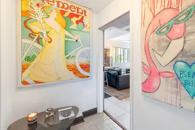 a hallway with a painting of a woman on a bike at Oceanfront Oasis 2-BR Apartment on Ocean Drive in Miami Beach