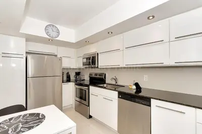 a kitchen with white cabinets and a clock on the ceiling at Hollywood Beach, 10th floor, on the beach 10T in Hollywood