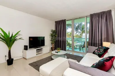 a living room with a white couch and a tv at Ocean front, full equiped, pool and parking 2M in Hollywood