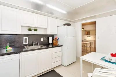 a kitchen with white cabinets and a white refrigerator at Ocean front, full equiped, pool and parking 2M in Hollywood