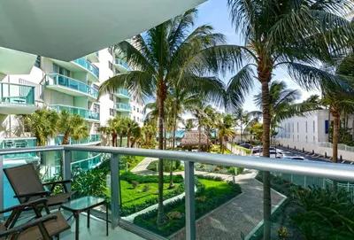 a balcony with palm trees and a building at Ocean front, full equiped, pool and parking 2M in Hollywood