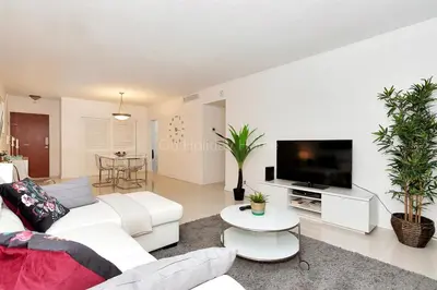 a living room with white furniture and a flat screen tv at Ocean front, full equiped, pool and parking 2M in Hollywood