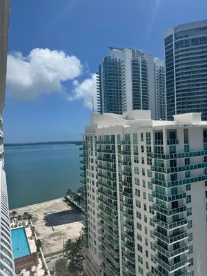 a view of a tall building with the ocean in the background at Brickell 2 bedroom condo in the heart of Miami in Miami