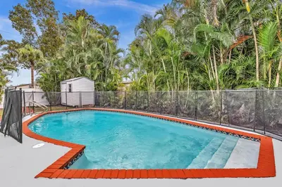 a swimming pool in a backyard with trees at Hollywood Beach & Casino Heated Pool House in Hollywood