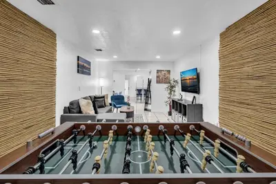 a living room with a ping pong table in the middle at Hollywood Beach & Casino Heated Pool House in Hollywood