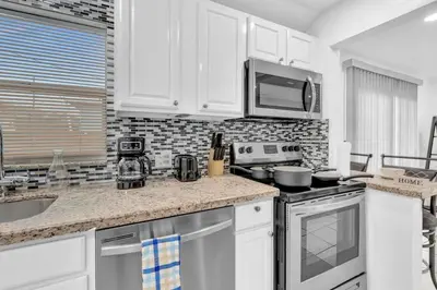 a kitchen with white cabinets and a stove top oven at Hollywood Beach & Casino Heated Pool House in Hollywood