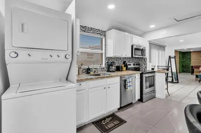 a kitchen with white cabinets and a white refrigerator at Hollywood Beach & Casino Heated Pool House in Hollywood