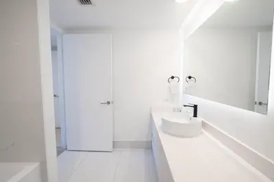 a white bathroom with a sink and a mirror at Miami Apt with Amazing Views & Kitchen in Hallandale Beach