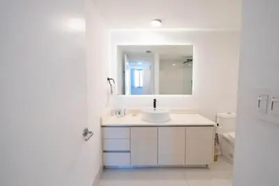 a white bathroom with a sink and a mirror at Miami Apt with Amazing Views & Kitchen in Hallandale Beach