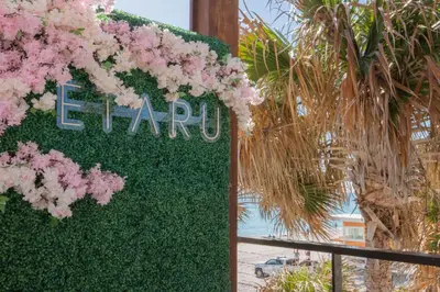 a sign with pink flowers on a fence at Miami Apt with Amazing Views & Kitchen in Hallandale Beach
