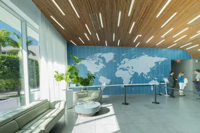 a lobby with a blue wall with a map of the world at Beachfront Apt with Pool by the Ocean in Hallandale Beach