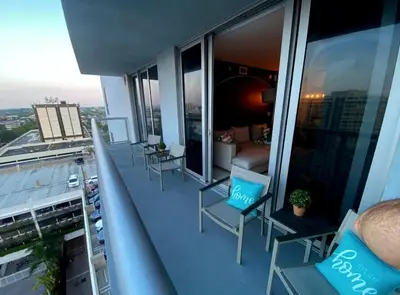 a balcony with chairs and a couch on a building at Beachfront Apt with Pool by the Ocean in Hallandale Beach