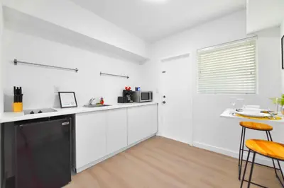 a kitchen with white cabinets and a black dishwasher at Stylish Studio Near Miami Relevant Spots in Miami