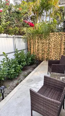 a patio with two chairs and a fence with flowers at Miami North Beach in North Miami Beach