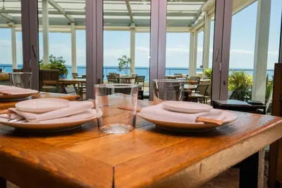 a wooden table with plates and glasses on it at Beautiful Studio in Hallandale with Beach & Pool in Hallandale Beach