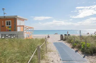 a beach with a building and a path to the beach at Amazing Studio Cozy at the Beach close to Mall in Hallandale Beach