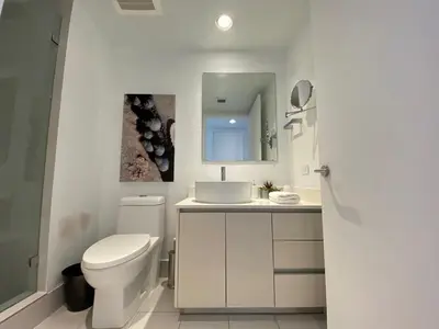 a bathroom with a toilet and a sink and a mirror at Amazing Studio Cozy at the Beach close to Mall in Hallandale Beach