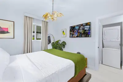 a white bedroom with a bed with a green blanket at 2BR, Families, Pets, Medical Stays, Hot Tub in Miami