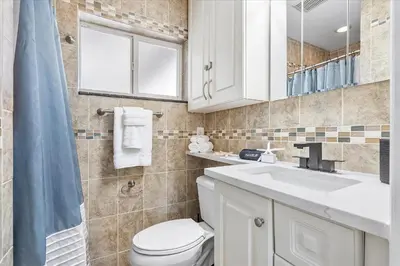 a bathroom with a toilet and a sink and a mirror at Blue Wave Retreat at Hollywood Beach home in Hollywood