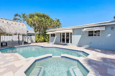 a swimming pool in front of a house at Blue Wave Retreat at Hollywood Beach home in Hollywood