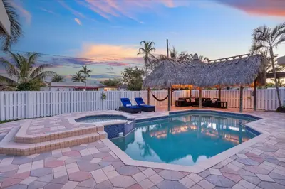 a swimming pool with two chairs and a gazebo at Blue Wave Retreat at Hollywood Beach home in Hollywood