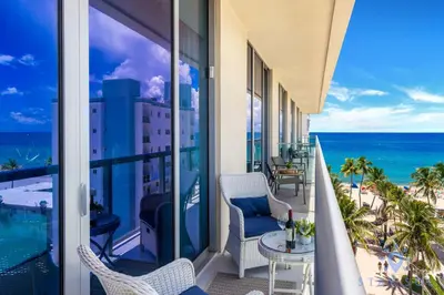 a balcony with chairs and a view of the ocean at Stylish Nice Apt Hollywood Beach Boardwalk in Hollywood