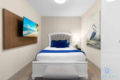 a bedroom with a large white bed with blue pillows at Stylish Nice Apt Hollywood Beach Boardwalk in Hollywood
