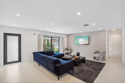 a living room with a blue couch and a table at Modern Luxury Home with Racket Sports Gym BBQ in Rockdale