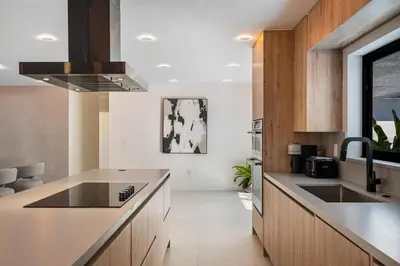 a kitchen with wooden cabinets and a counter top at Modern Luxury Home with Racket Sports Gym BBQ in Rockdale