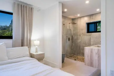 a bedroom with a bed and a bathroom with a shower at Modern Luxury Home with Racket Sports Gym BBQ in Rockdale