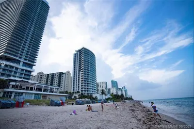 a group of people on a beach with buildings at Miami Beach 1B 1B w Kitchen and Beach Service in Hallandale Beach