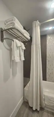 a bathroom with a shower with a white shower curtain at City view with balcony on the Beach in Sunny Isles Beach