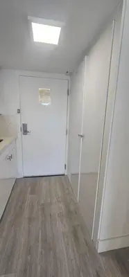 a room with a white door and a room with wood floors at City view with balcony on the Beach in Sunny Isles Beach