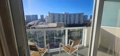 a balcony with two chairs and a view of a city at City view with balcony on the Beach in Sunny Isles Beach