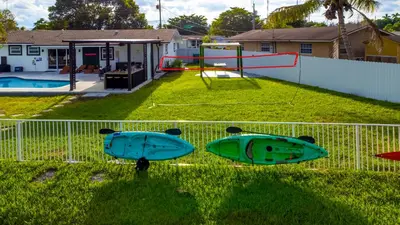 two surfboards sitting on the grass next to a fence at Hard Rock Paradise in Andover Lakes Estates