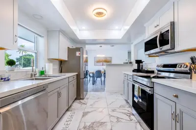 a large kitchen with white cabinets and appliances at Hard Rock Paradise in Andover Lakes Estates