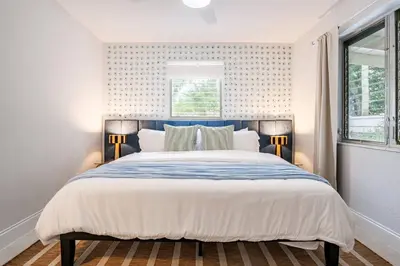 a bedroom with a large bed with a blue headboard at Central 3BD wPool and Covered Patio 10 min to FLL in Fort Lauderdale