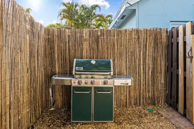 a stove with a laptop on top of it next to a fence at Beach Home in Victoria Park in Fort Lauderdale
