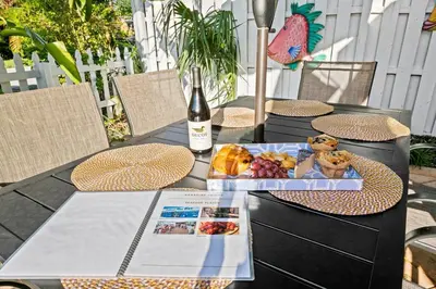 a table with a bottle of wine and food on it at Beach Home in Victoria Park in Fort Lauderdale