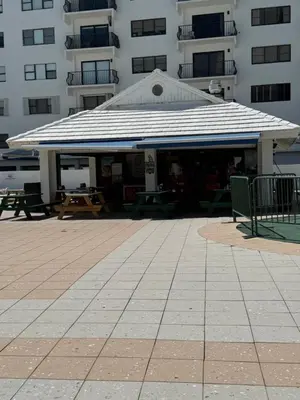 a building with a pavilion with tables and benches at Castle beach studio,tennis court and swimming pool with beach access in Miami Beach