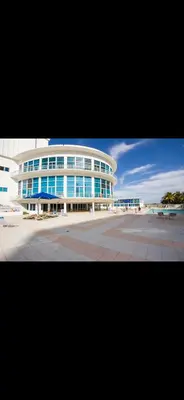 a large building with blue windows and a parking lot at Castle beach studio,tennis court and swimming pool with beach access in Miami Beach