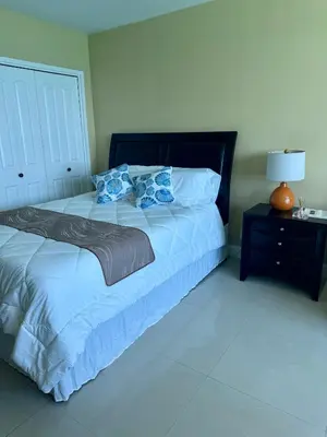 a bedroom with a large bed with blue pillows at Castle beach studio,tennis court and swimming pool with beach access in Miami Beach