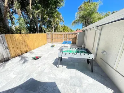 a backyard with a ping pong table and a fence at La Dolce Villa in Fort Lauderdale