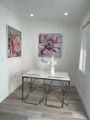 a table and chairs in a room with paintings at Beautiful House in Coral Gables FL in Miami